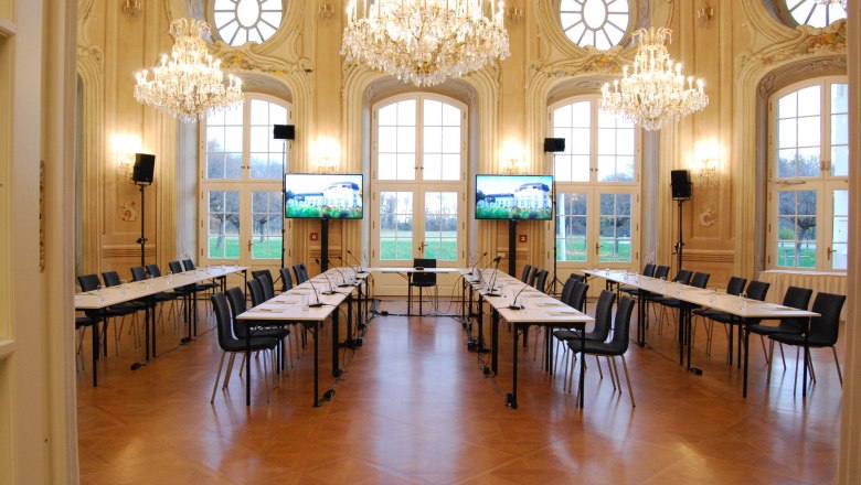 Laxenburg Conference Center, © Event Residenzen Niederösterreich Elegant conference room with chandeliers and large windows.