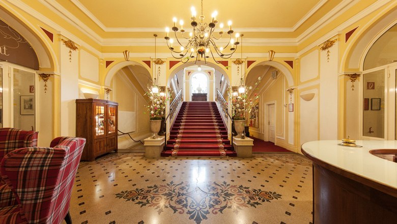 Marienhof Lobby, © Hotel Marienhof Elegant lobby with red carpet, staircase and chandelier.