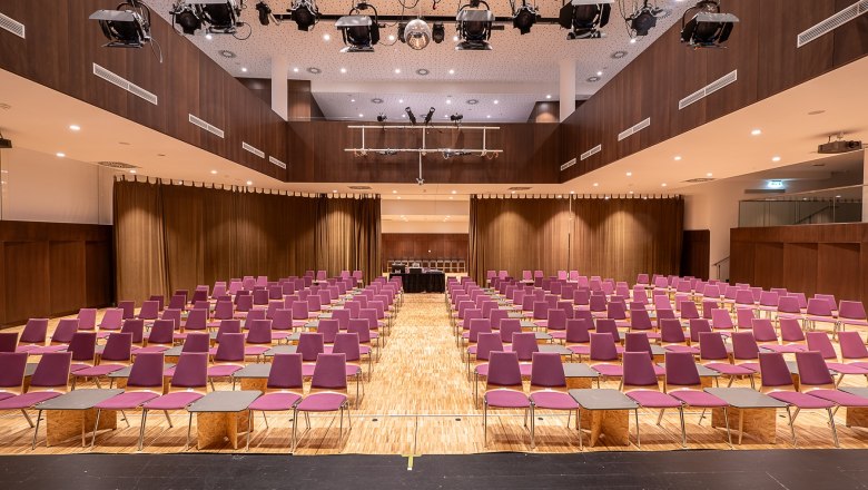Danubium Tulln, © TullnKultur, HansEder Interior view of an empty event room with purple chairs and wooden floor.