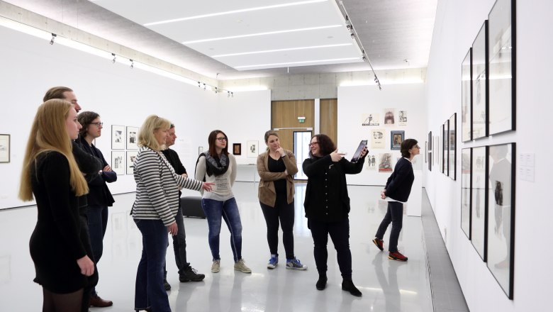 Kunstmeile Krems, © Redtenbacher Group of people in an art gallery looking at works of art on the wall.