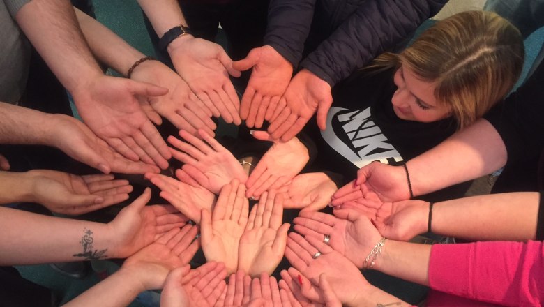 TEAMbuilder, © TEAMbuilder Several hands form a circle, palms up.