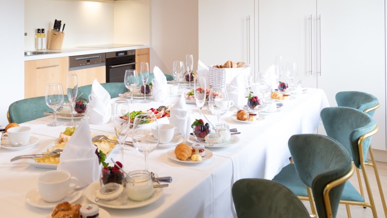 Villa Schönthaler, kitchen, © Event Residenzen Niederösterreich Elegant breakfast table in modern kitchen with laid table, crockery and dishes.