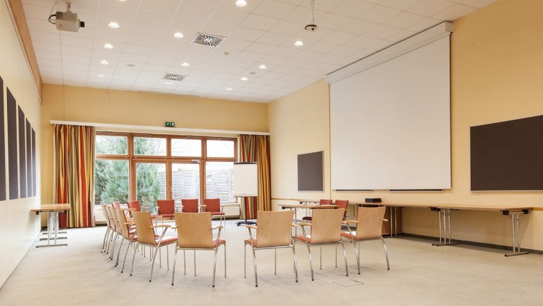 Seminar room, © Traumbild - Gerhard Wolkersdorfer An empty seminar room with a circle of chairs, projector, screen and flipchart.
