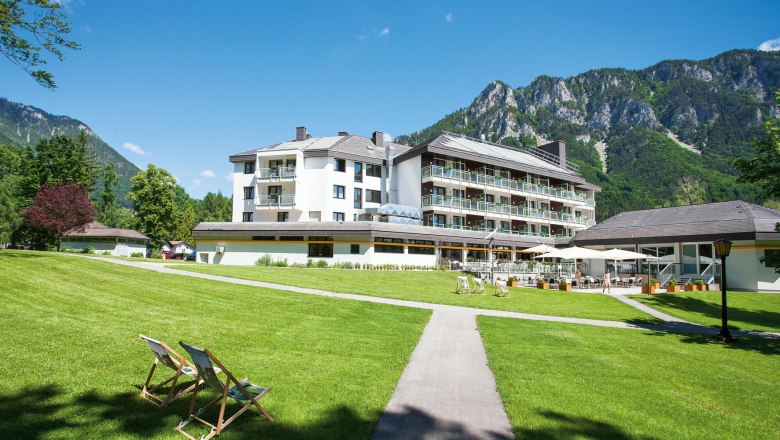 Parkhotel Hirschwang, © missionINGE.com Parkhotel Hirschwang against a mountain backdrop with a green lawn and sun loungers.