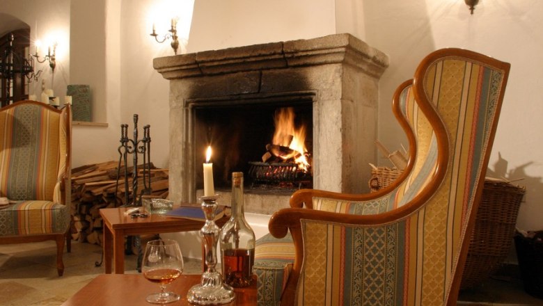 Fireplace hall, © Hotel Richard Löwenherz Cozy fireplace lounge with a burning fireplace, armchairs and table with drinks.