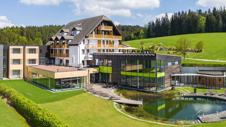 Hotel Schwarz Alm, © Schwarz Alm Zwettl, Rudolf Schmied Hotel Schwarz Alm with modern design, surrounded by green landscape and forest.