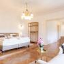 Villa Schönthaler, © Event Residenzen Niederösterreich Elegant bedroom with double bed, chandelier and fireplace.