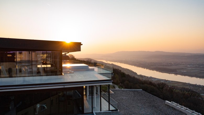 Outdoor infinity pool Hotel Schachner, © Hotel Schachner_MIKU Media Infinity pool at Hotel Schachner with a view of the river landscape at sunset.