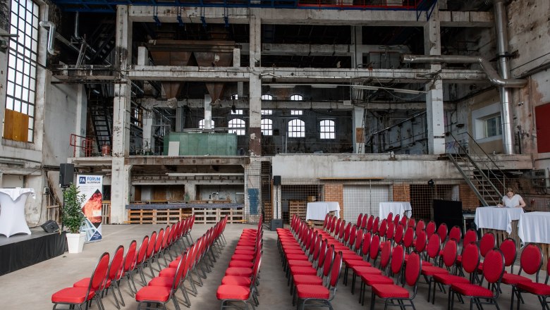 Glanzstoff Events, Kesselhaus, © www.partybox.at Interior view of an old boiler house with red chairs and event decorations.