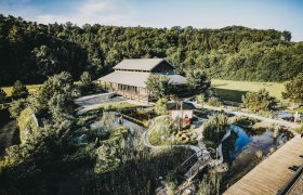 Exterior view of the Linsberg Asia Resort with its garden and pond.