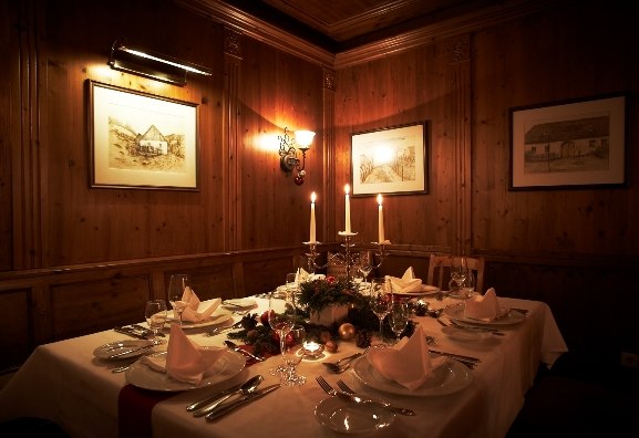 Festively laid table in a cozy wine bar with candlelight and wooden walls.