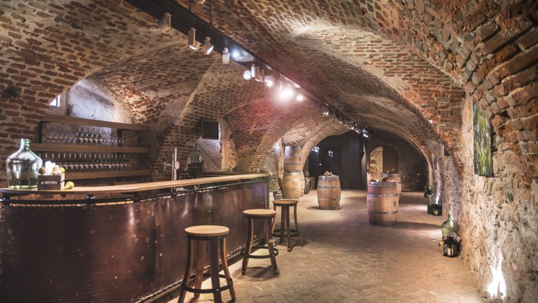 Historic castle cellar with brick walls, bar and wooden barrels.