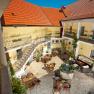 Inner courtyard of the Wachau Residence with tables, chairs and a fountain.