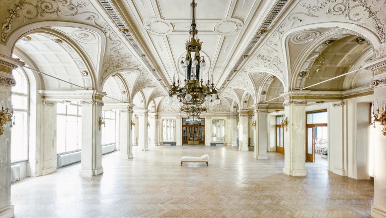 Large, elegant dining room with ornate ceilings and chandeliers in the S&uuml;dbahnhotel.