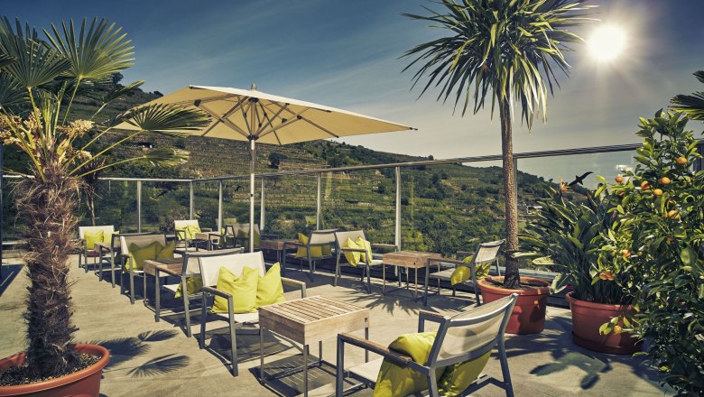 Terrace of the Steigenberger Krems with parasols and plants.