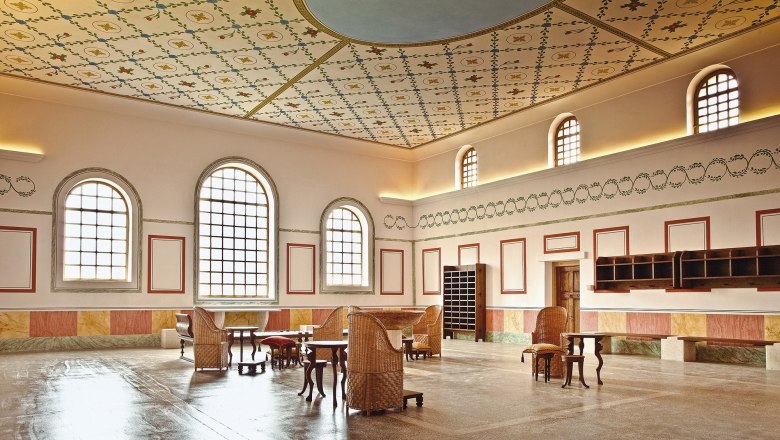 Interior view of the Roman town of Carnuntum thermal baths with decorative ceiling and antique furniture.