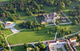 Aerial view of Grafenegg Castle with surrounding park and modern stage.