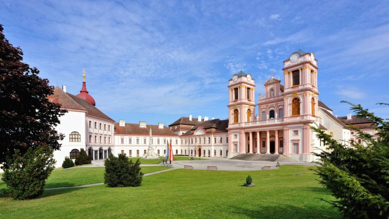 Göttweig Abbey with its baroque architecture and green forecourt under a blue sky.