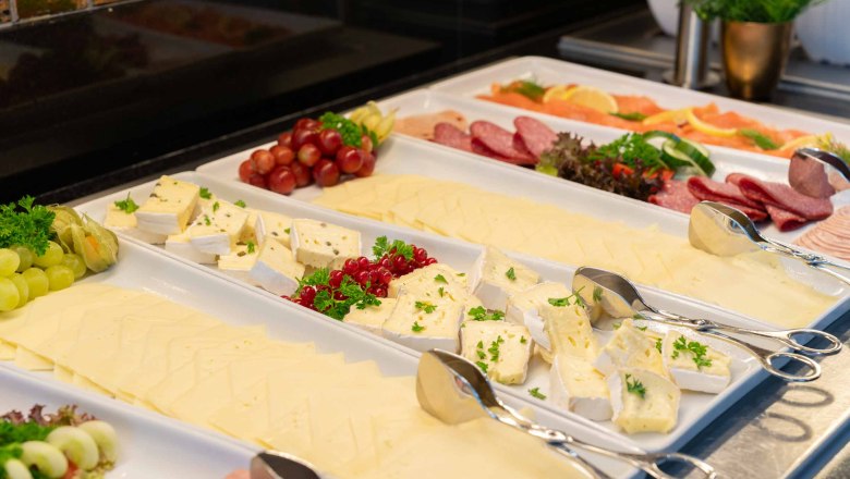 Buffet with cheese, sausage and fruit.
