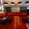 Modern hotel lobby with red furniture and artwork on the wall.