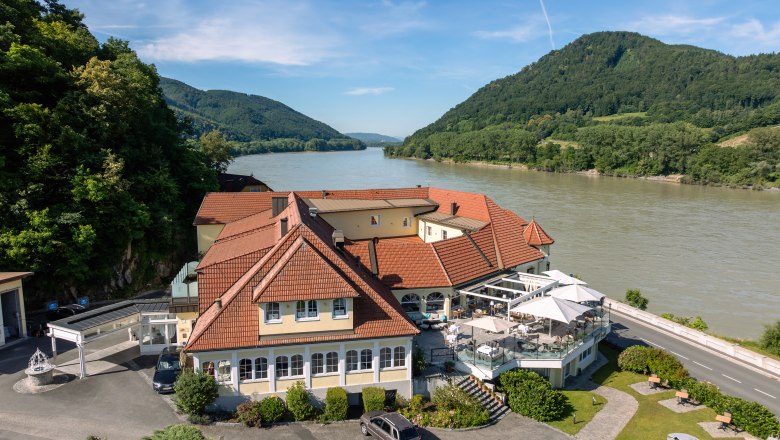 Hotel ResidenzWachau on the banks of the river with surrounding hills.