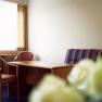 Hotel room with table, chairs and sofa.