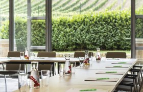 Seminar room with tables, chairs and a view of the vineyards.