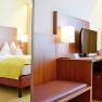 Double room in the Wachauerhof with bed, desk, TV and chair.
