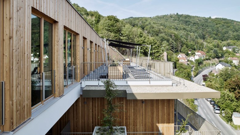 Modern spa terrace with wooden cladding and views of wooded hills.