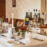 Elegant table in hotel restaurant with wine glasses, candle and flowers.