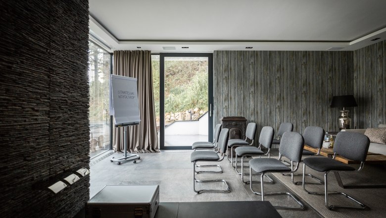 Modern conference room with gray chairs, flipchart and large windows.