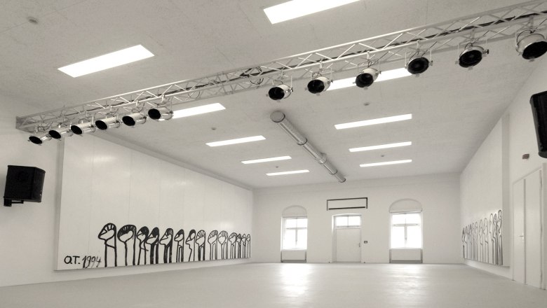 Interior view of a white room with wall paintings and lighting.