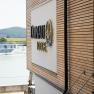 Building with wooden cladding and 'Donau Lodge' lettering, with the Danube and a ship in the background.