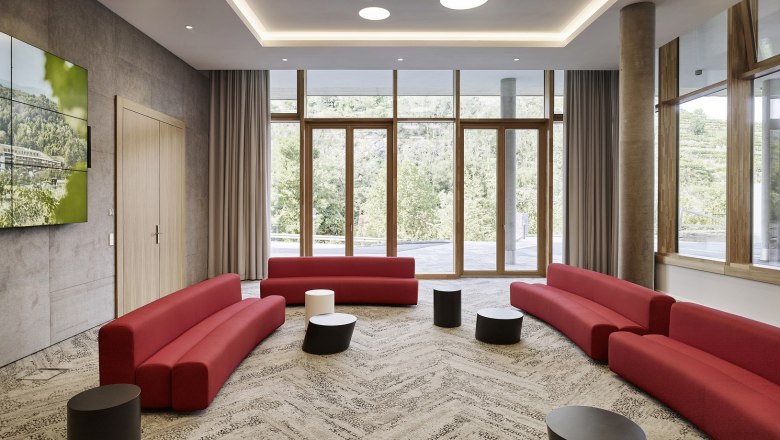 Modern conference room with red sofas and large windows at the Steigenberger Krems.
