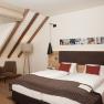 Comfortable hotel room with double bed, seating area and sloping roof.