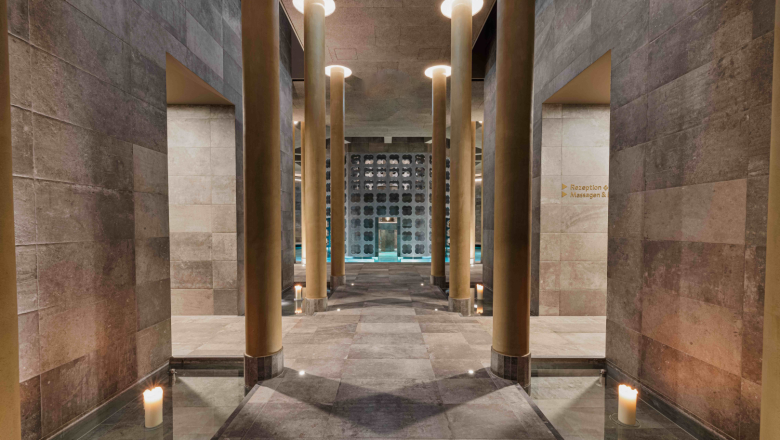 Interior view of an elegant spa area with pillars and candles.