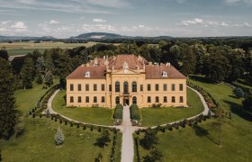 Aerial view of Eckartsau Castle surrounded by green countryside.