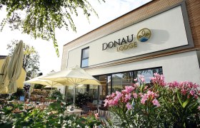 Exterior view of the Donau Lodge Ybbs with terrace and parasols.