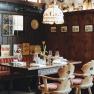 Cozy restaurant with wooden walls, red striped benches and a table setting.