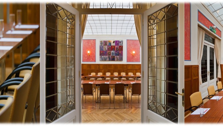 Conference room in the Hotel Herzoghof with long tables, chairs and presentation equipment.
