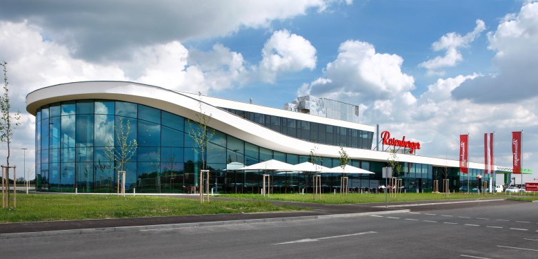 Modern building with glass façade and curved roof.