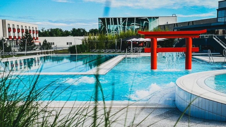 Exterior view of the Linsberg Asia Therme with pool and red torii.