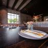 Elegant restaurant with laid table, gold-colored cutlery and flowers.