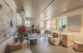 A stylishly furnished room with modern furniture, plants and works of art on the walls.