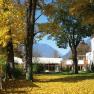 Autumn scene with hotel building and yellow leaves on the ground.
