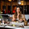 Woman enjoys an elegant dinner in a stylish restaurant.