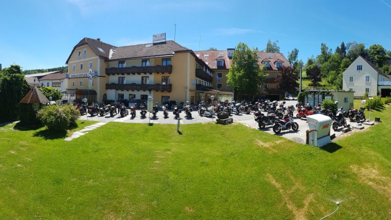 Hotel Waldviertler-Hof with many motorcycles parked in front of it.