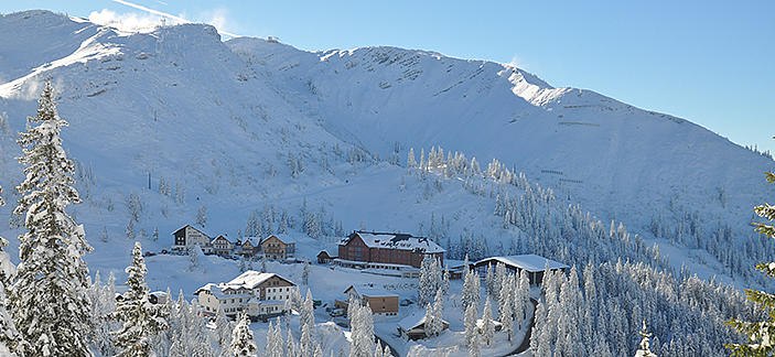 Winter landscape with snow-covered mountains and buildings on the Hochkar.