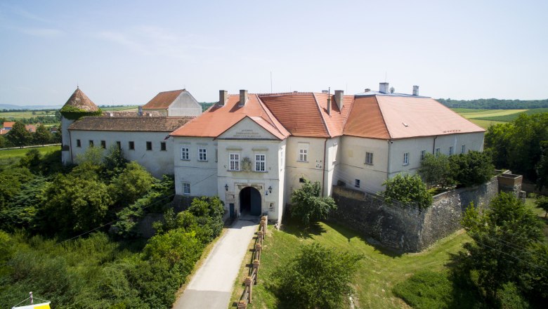 Aerial view of Mailberg Castle with red roofs and surrounding landscape.