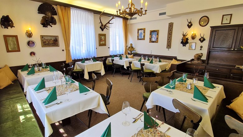 A traditionally decorated dining room with hunting trophies on the walls and laid tables.